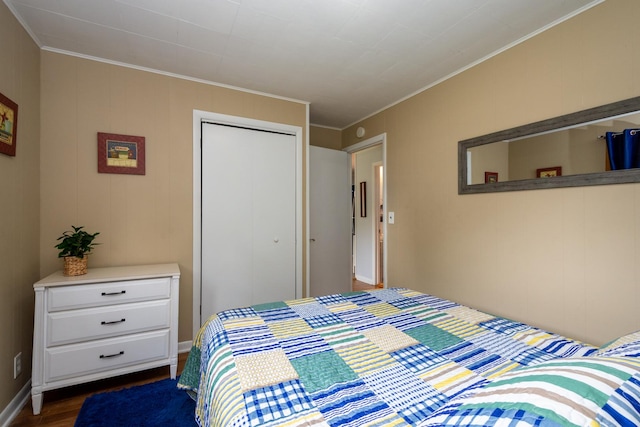 bedroom with dark hardwood / wood-style floors, ornamental molding, and a closet