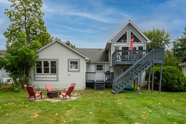 rear view of house with a fire pit, a patio area, a deck, and a yard