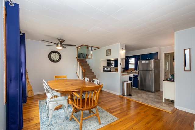 dining space with ceiling fan, sink, and light wood-type flooring