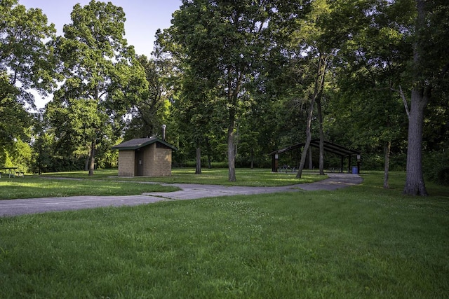 view of property's community featuring a yard and a shed