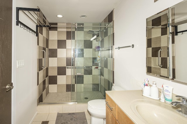 bathroom featuring walk in shower, vanity, tile patterned flooring, and toilet