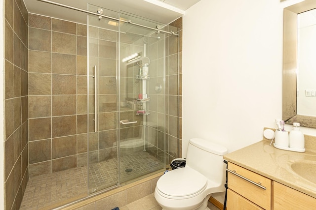 bathroom with toilet, a shower with door, and vanity