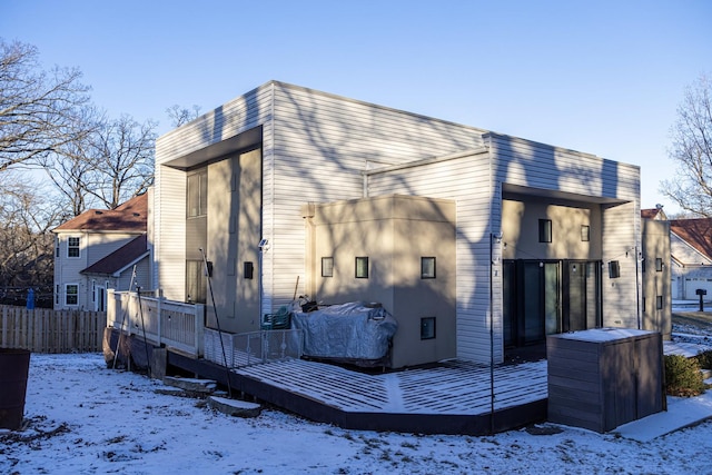 snow covered house with a wooden deck