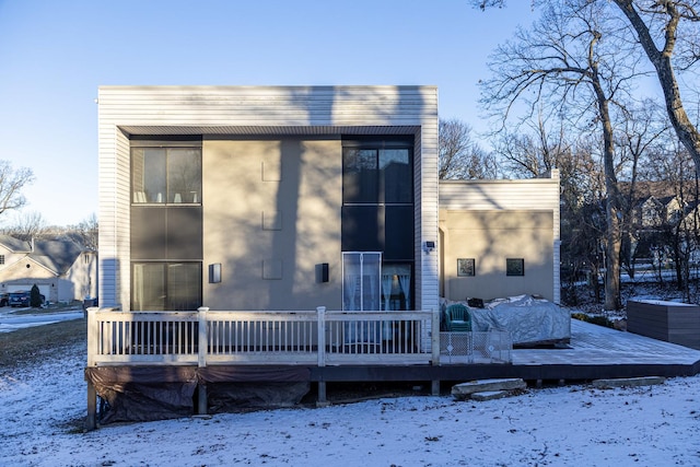 snow covered house featuring a deck