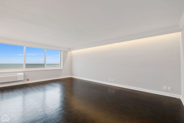 unfurnished room with a water view, an AC wall unit, and ornamental molding