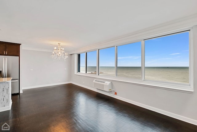 unfurnished room featuring a wall unit AC, a water view, ornamental molding, and a notable chandelier