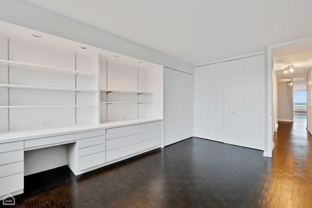 interior space with dark parquet flooring and built in desk