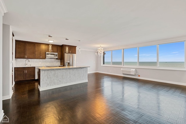 kitchen with a center island, a water view, sink, decorative backsplash, and stainless steel appliances