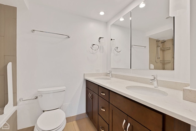 bathroom with walk in shower, vanity, and toilet