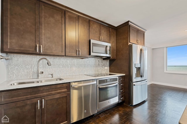 kitchen with dark brown cabinetry, stainless steel appliances, dark parquet floors, and sink