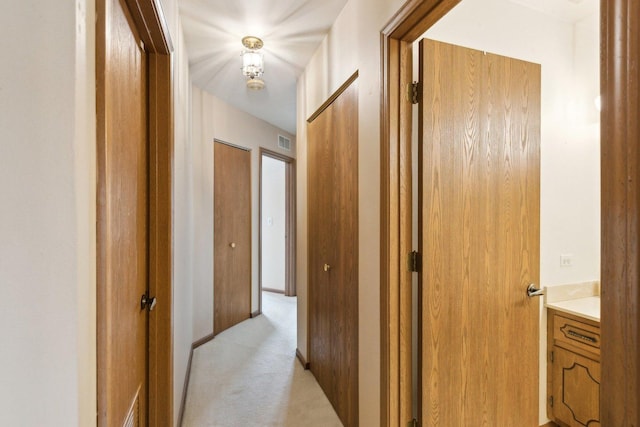 hallway with light colored carpet