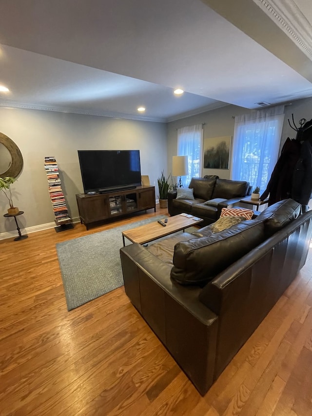 living room with wood-type flooring and ornamental molding