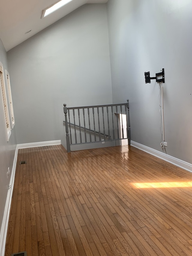 interior space featuring lofted ceiling with skylight and wood-type flooring