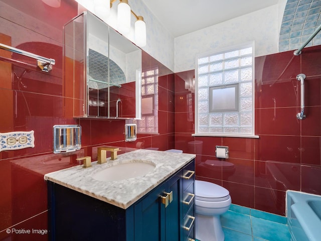 bathroom with toilet, vanity, tile patterned flooring, tile walls, and a bath