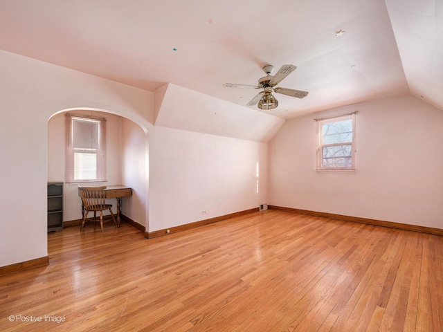 additional living space with light wood-type flooring, vaulted ceiling, and plenty of natural light