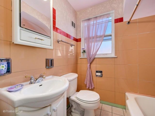 bathroom featuring toilet, tile patterned flooring, a bathtub, and vanity