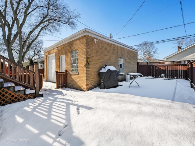 view of snowy exterior with a garage