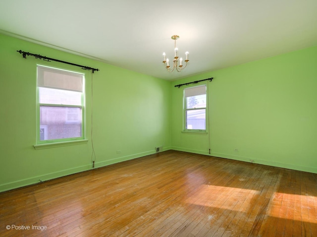 unfurnished room with a chandelier and light hardwood / wood-style flooring