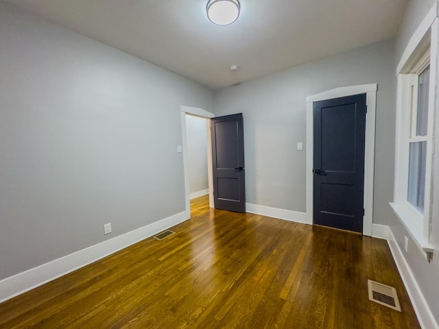 unfurnished bedroom with dark hardwood / wood-style floors