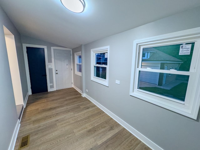 hallway featuring hardwood / wood-style floors and lofted ceiling