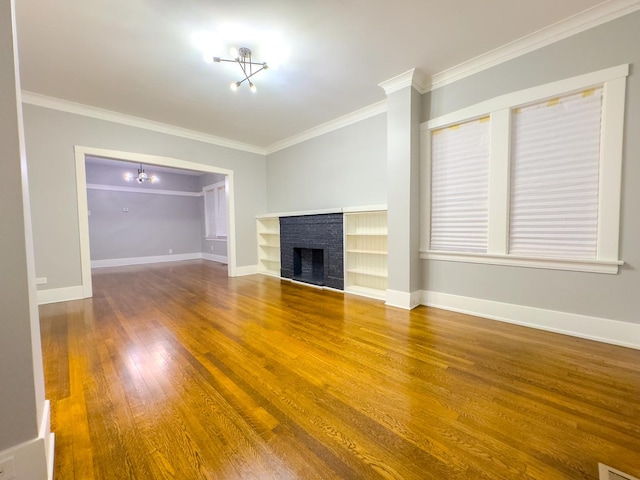 unfurnished living room featuring hardwood / wood-style flooring, ornamental molding, and a brick fireplace