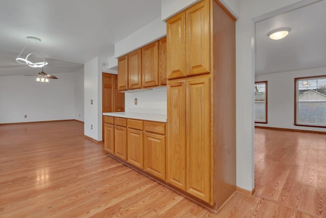 kitchen with ceiling fan and light hardwood / wood-style flooring