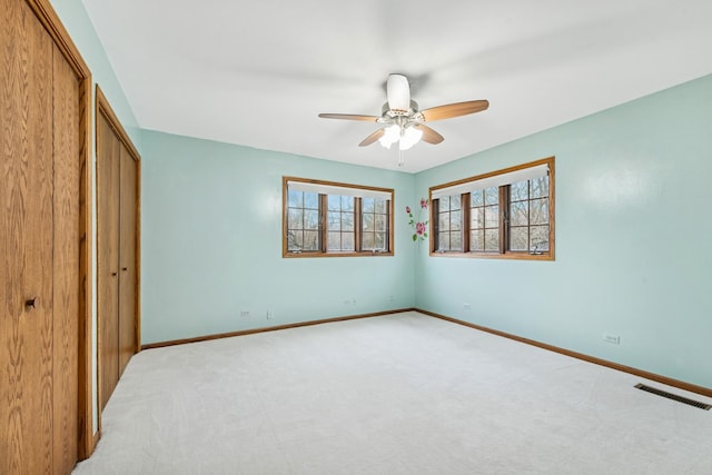 unfurnished bedroom featuring baseboards, a closet, visible vents, and light colored carpet