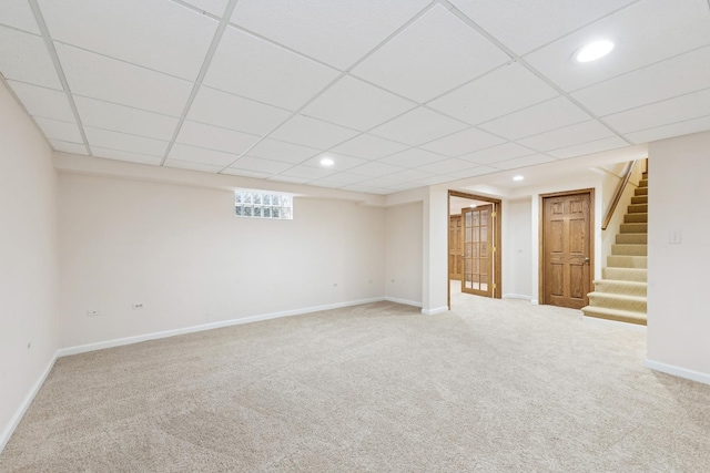 basement with a paneled ceiling, recessed lighting, baseboards, stairs, and carpet