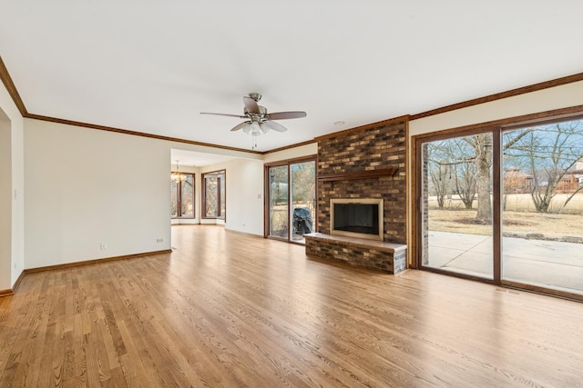 unfurnished living room with a fireplace, light wood finished floors, ornamental molding, baseboards, and ceiling fan with notable chandelier