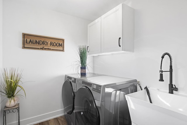 laundry room featuring cabinets, hardwood / wood-style floors, sink, and washing machine and clothes dryer