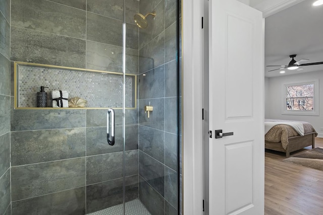 bathroom with ceiling fan, wood-type flooring, and a shower with door