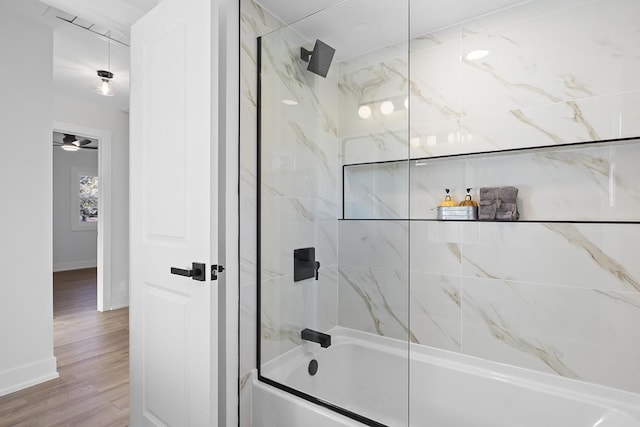 bathroom with hardwood / wood-style floors and tiled shower / bath combo