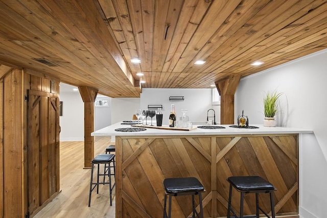 bar with sink, wood ceiling, and light wood-type flooring