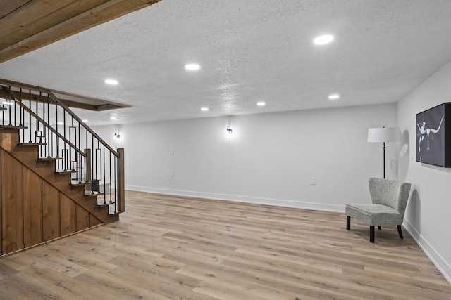 interior space featuring light wood-type flooring and a textured ceiling