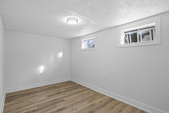 basement featuring hardwood / wood-style floors and a textured ceiling