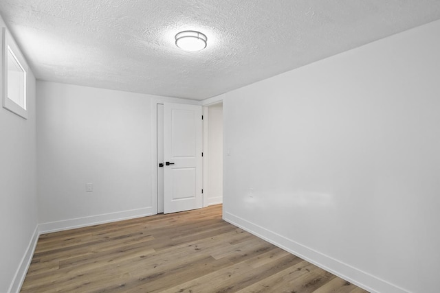 empty room featuring hardwood / wood-style flooring and a textured ceiling