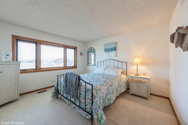 bedroom featuring light carpet and a textured ceiling