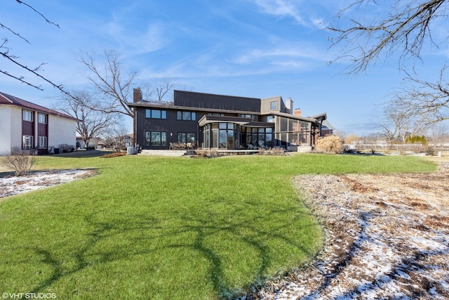 back of house with a sunroom and a yard