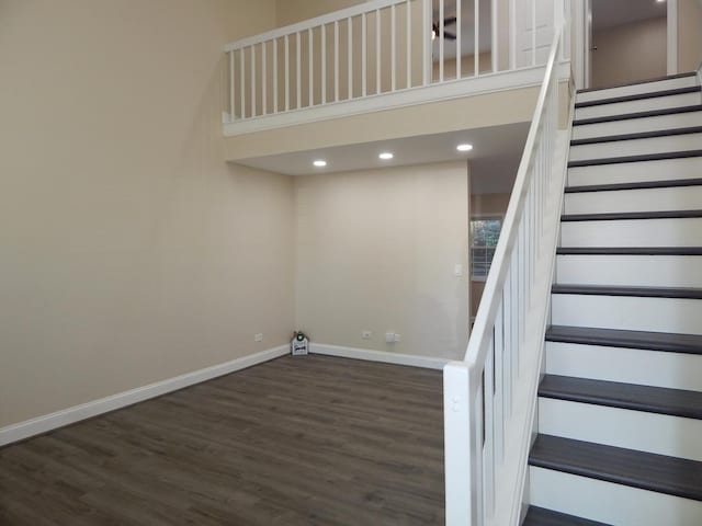 stairs with a high ceiling and hardwood / wood-style flooring