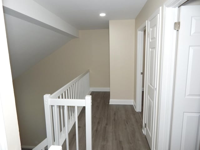 hallway with dark hardwood / wood-style floors and vaulted ceiling