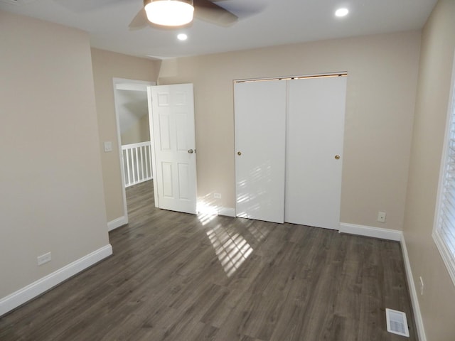 unfurnished bedroom with dark hardwood / wood-style flooring, ceiling fan, and a closet