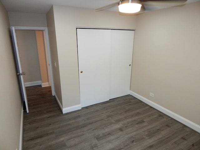 unfurnished bedroom with a closet, ceiling fan, and dark wood-type flooring