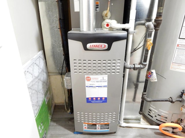 utility room with heating unit and gas water heater