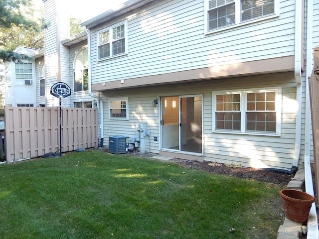 back of house featuring a lawn and central air condition unit