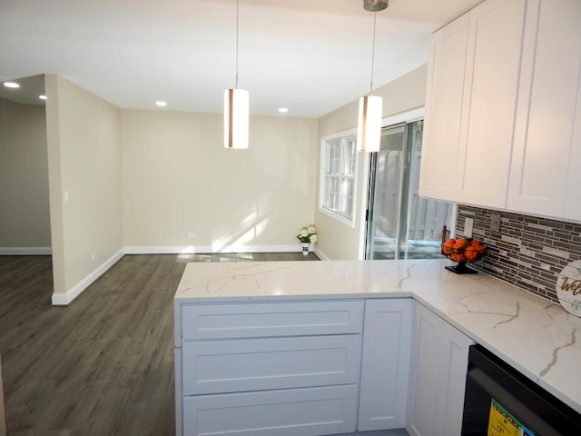 kitchen with white cabinetry, hanging light fixtures, and light stone counters