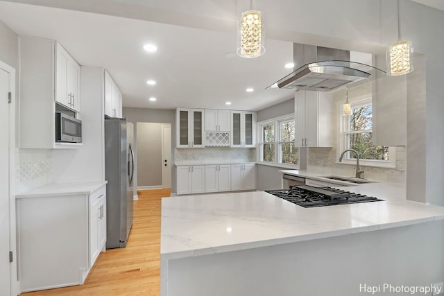 kitchen with stainless steel appliances, white cabinets, and hanging light fixtures