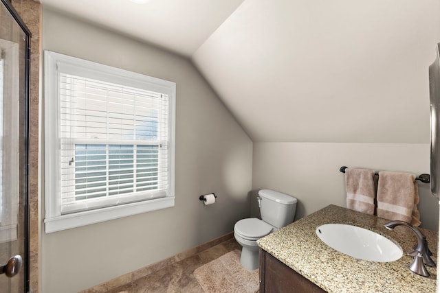 bathroom featuring a shower with door, vaulted ceiling, vanity, and toilet