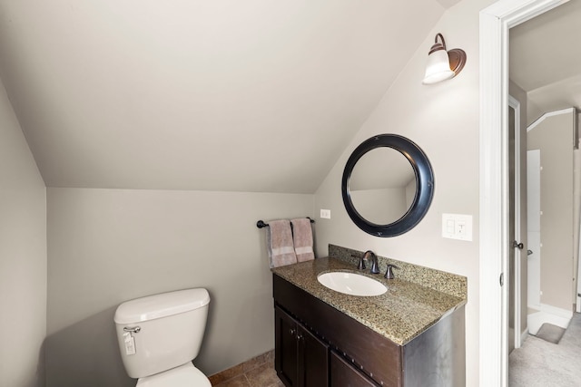 bathroom with lofted ceiling, vanity, and toilet