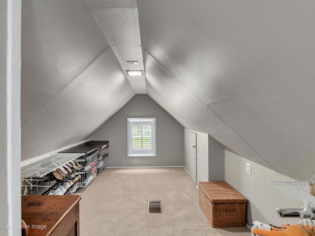 bonus room featuring vaulted ceiling and carpet floors