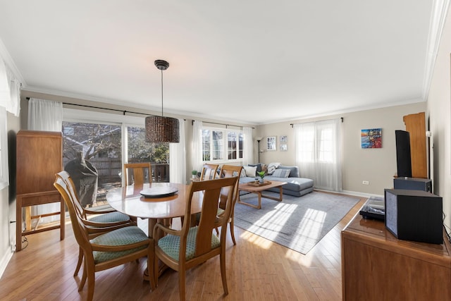 dining space featuring crown molding and light wood-type flooring